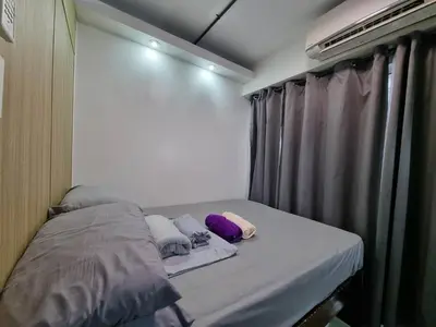 a small bed with pillows on it in a room at Industrial Design Bachelor's Pad with Pool View in Shore Residences in Manila