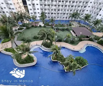 an aerial view of a resort with a water park at Industrial Design Bachelor's Pad with Pool View in Shore Residences in Manila