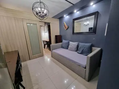 a living room with a bed and a mirror at Industrial Design Bachelor's Pad with Pool View in Shore Residences in Manila