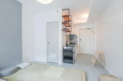 a living room with a refrigerator and a table at Japanese Stylish Condo in Makati in Manila