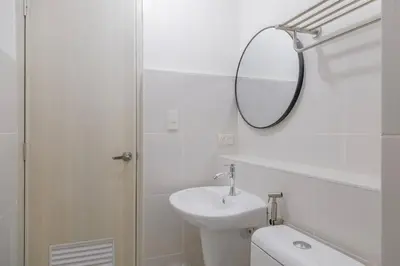 a white bathroom with a sink and a mirror at Japanese Stylish Condo in Makati in Manila