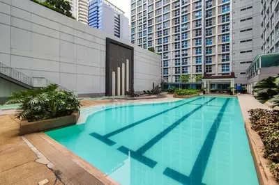 a large swimming pool in a city with tall buildings at Japanese Stylish Condo in Makati in Manila