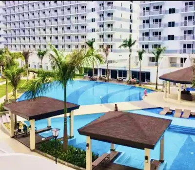 a large swimming pool in front of a large building at Near MOA Manila Bay Airport via NAIAX Balcony-Pool View WiFi SHELL Residences in Manila