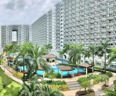 an aerial view of a resort with a pool and palm trees at Near MOA Manila Bay Airport via NAIAX Balcony-Pool View WiFi SHELL Residences in Manila