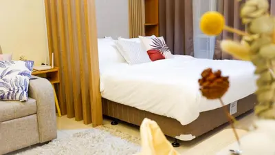 a bedroom with a bed with white sheets and pillows at New Cozy Condo in Eastwood in Manila