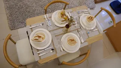 a table with plates and bowls on it in a kitchen at New Cozy Condo in Eastwood in Manila