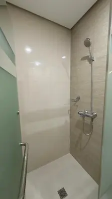 a bathroom with a shower with a glass door at New Cozy Condo in Eastwood in Manila
