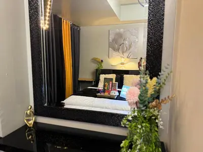 a bedroom with a bed and a large mirror at Oasis City Ventures in Manila