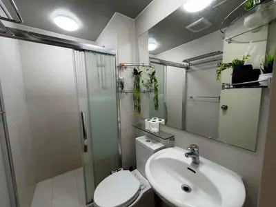 a bathroom with a toilet and a sink and a shower at Oasis City Ventures in Manila