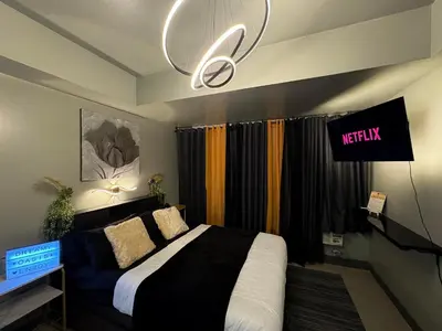 a bedroom with a bed and a chandelier at Oasis City Ventures in Manila