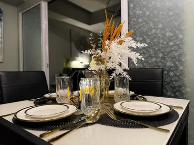 a dining room table with plates and glasses on it at Oasis City Ventures in Manila