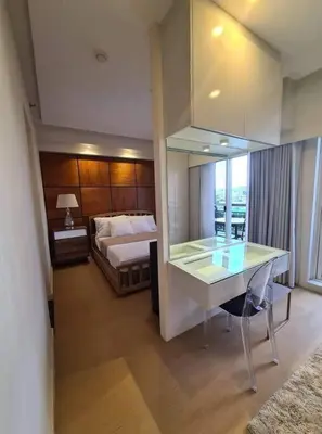 a hotel room with a bed and a desk in a room at 3BR Elegant & Central Loc- Netflix, WiFi, MiniBar! in Manila