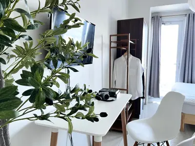 a room with plants and a white table and a mirror at Vibrant Makati Studio in Manila
