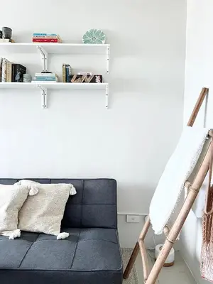 a black couch in a room with a shelf at Vibrant Makati Studio in Manila