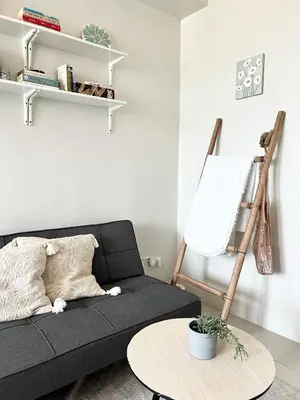 a living room with a black couch and a table at Vibrant Makati Studio in Manila