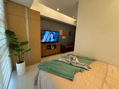 a bedroom with a teddy bear laying on a bed at Staycation in Mckinley walking distance to Venice Mall in Manila