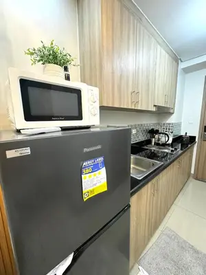 a microwave on top of a refrigerator in a kitchen at Gray Room Shore 2 Residences in Manila