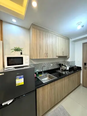 a kitchen with a sink and a microwave at Gray Room Shore 2 Residences in Manila