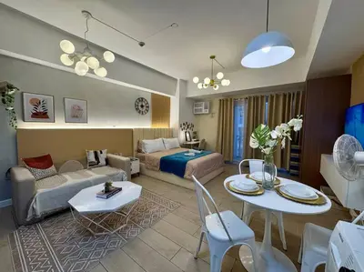 a living room with a couch and a bed and a table at Staycation in venice residences Mckinley with balcony in Manila