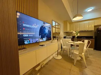 a kitchen with a large flat screen tv on the wall at Staycation in venice residences Mckinley with balcony in Manila