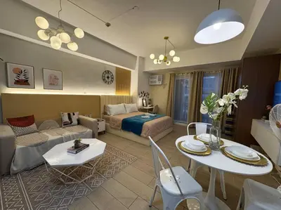 a living room with a bed and a couch and a table at Staycation in venice residences Mckinley with balcony in Manila