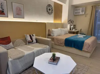a living room with two beds and a couch at Staycation in venice residences Mckinley with balcony in Manila
