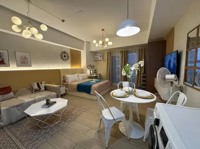 a living room with a couch and a table at Staycation in venice residences Mckinley with balcony in Manila