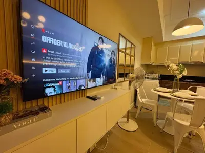 a kitchen with a large screen on the wall at Staycation in venice residences Mckinley with balcony in Manila