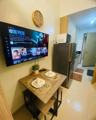 a small kitchen with a table and a refrigerator at Shore 2 Residences Tuscia Home Staycation in Manila