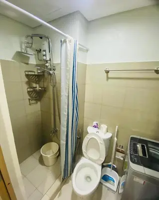 a small bathroom with a toilet and a shower at Shore 2 Residences Tuscia Home Staycation in Manila