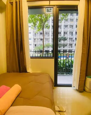 a bedroom with a window with a view of a building at Shore 2 Residences Tuscia Home Staycation in Manila