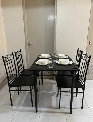 a black table with chairs and plates on it at 2 Bedroom condo unit in Manila