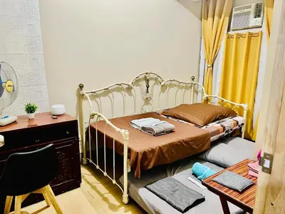 a bedroom with a bed and a desk and a chair at 2 Bedroom condo unit in Manila
