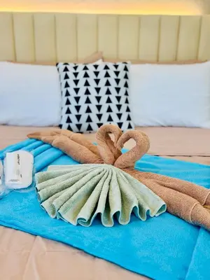 a bed with two towels on top of it at Budget Friendly Staycation walking distance to Venice Mall with Netflix and Wifi in Manila