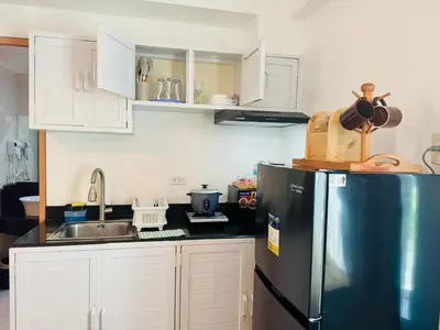 a kitchen with a stainless steel refrigerator and white cabinets at Budget Friendly Staycation walking distance to Venice Mall with Netflix and Wifi in Manila