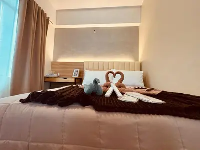 a bed with two stuffed animals and an x on it at Budget Friendly Staycation walking distance to Venice Mall with Netflix and Wifi in Manila