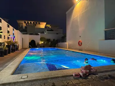a person swimming in a swimming pool at night at Budget Friendly Staycation walking distance to Venice Mall with Netflix and Wifi in Manila
