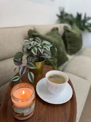 a cup of coffee and a candle on a table at Cozy place across Mitsukoshi Mall in Manila