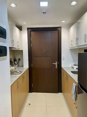 a kitchen with a wooden door in the middle at Cozy place across Mitsukoshi Mall in Manila