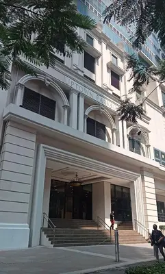 a large building with a staircase in front of it at Cozy place across Mitsukoshi Mall in Manila