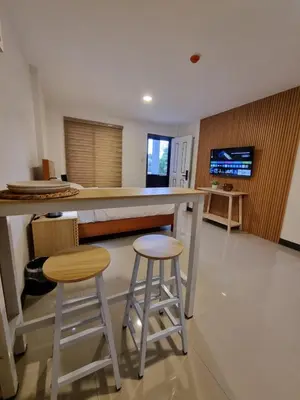 a kitchen with two stools and a bar with a tv at Flat 35, Unit F in Manila