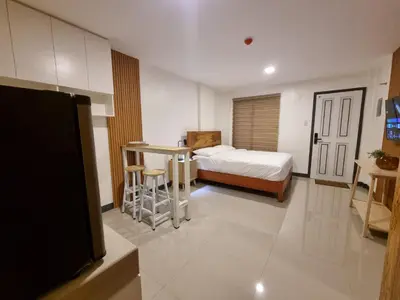 a bedroom with a bed and a table and a tv at Flat 35, Unit F in Manila