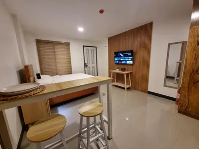 a bedroom with a bed and a bar with two stools at Flat 35, Unit F in Manila