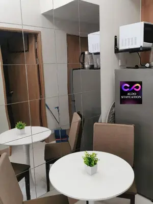 two white tables and chairs in a room at Shore 3 tower 2 mall of Asia in Manila