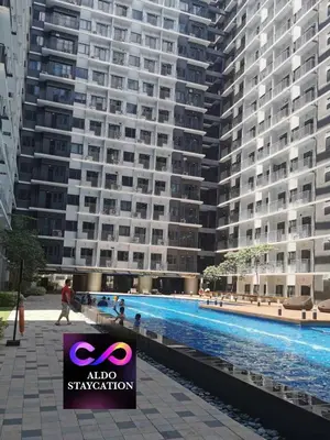a large apartment building with a large swimming pool at Shore 3 tower 2 mall of Asia in Manila