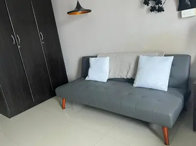 a couch with two pillows on it in a room at Cozy Makati Condo Getaway with balcony in Manila