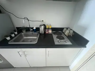 a kitchen counter with a sink and a stove at Cozy Makati Condo Getaway with balcony in Manila