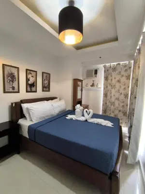 a bedroom with a bed with a blue comforter at Explore Manila, Trendy 1BR unit in Prime Location in Manila