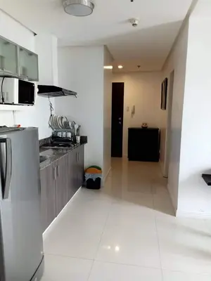 a kitchen with a stainless steel refrigerator and a stove at Explore Manila, Trendy 1BR unit in Prime Location in Manila