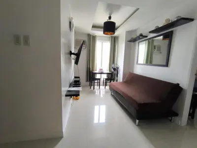 a bedroom with a bed and a table and a mirror at Explore Manila, Trendy 1BR unit in Prime Location in Manila